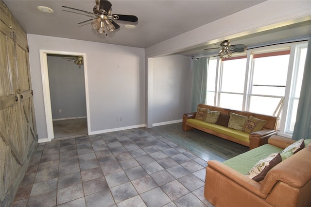 unfurnished living room featuring baseboards and ceiling fan