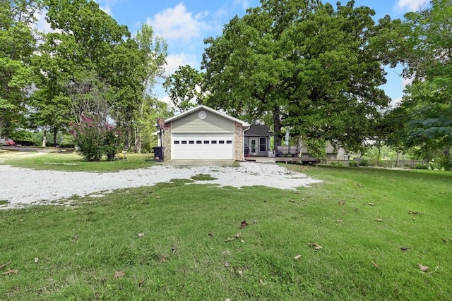 view of yard featuring a garage, gravel driveway, and a deck