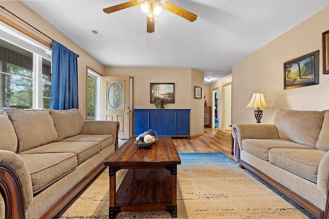 living room featuring ceiling fan and light hardwood / wood-style flooring