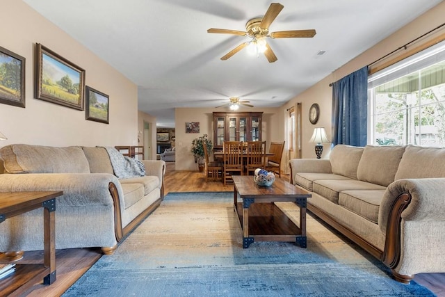 living area with ceiling fan and wood finished floors