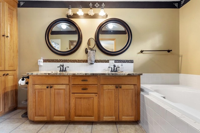 bathroom featuring a sink, tile patterned floors, tiled bath, and double vanity