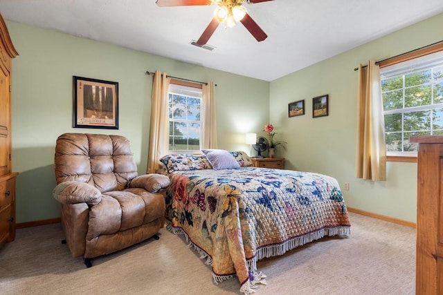 bedroom with baseboards, visible vents, multiple windows, and light carpet