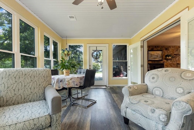 sunroom / solarium featuring plenty of natural light, ornamental molding, wood finished floors, and visible vents