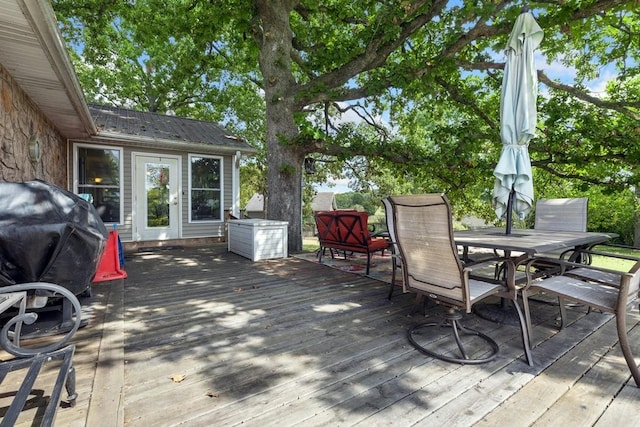 wooden deck with outdoor dining space and a grill