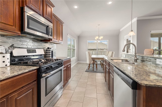 kitchen featuring pendant lighting, sink, light tile patterned flooring, stainless steel appliances, and a chandelier