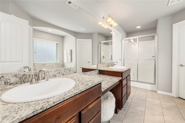 bathroom with tile patterned floors, vanity, and a shower with door