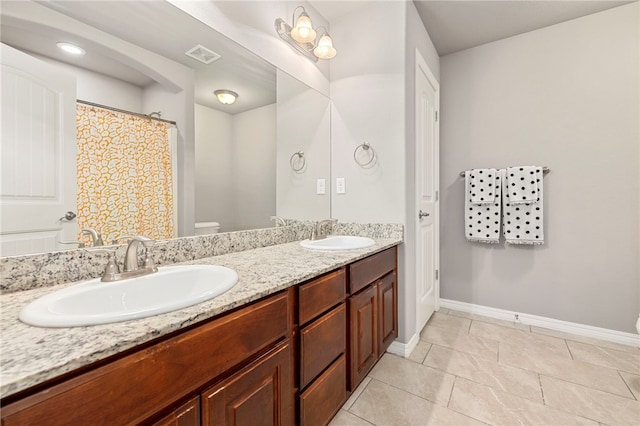 bathroom with tile patterned floors, vanity, toilet, and curtained shower