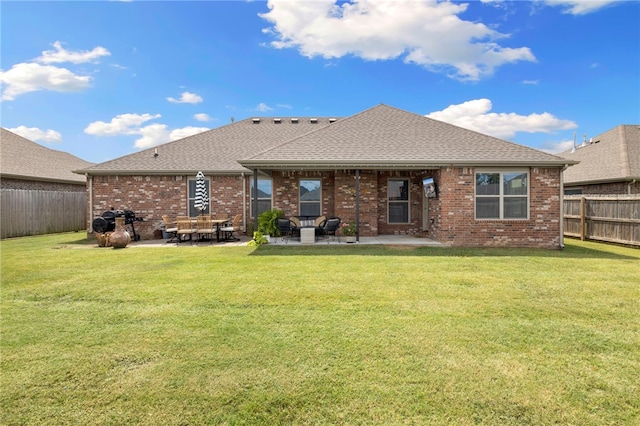 rear view of house with a lawn and a patio area