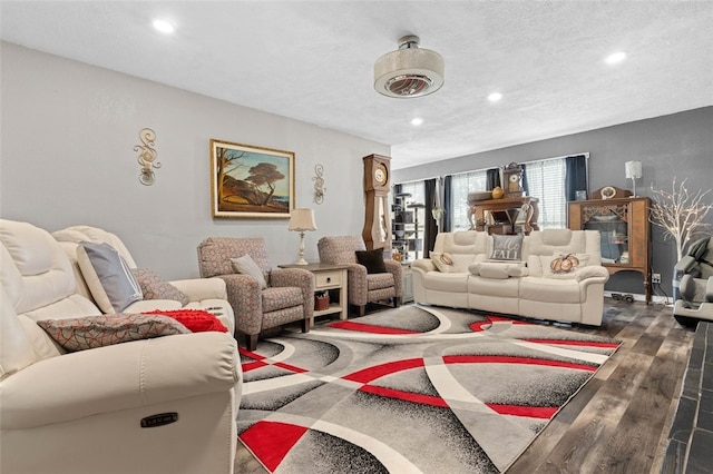 living room with a textured ceiling and dark hardwood / wood-style floors