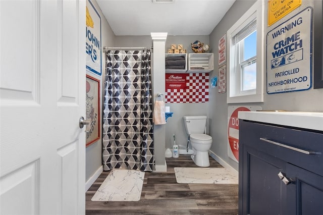 bathroom featuring walk in shower, vanity, toilet, and hardwood / wood-style flooring