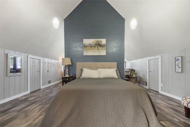 bedroom featuring wooden walls, vaulted ceiling, and dark hardwood / wood-style flooring