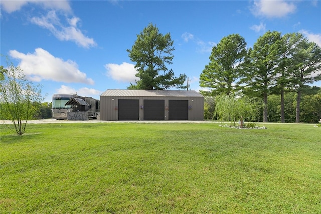 view of yard with a garage and an outbuilding