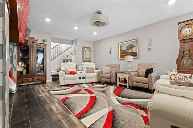 living room with a textured ceiling and dark wood-type flooring