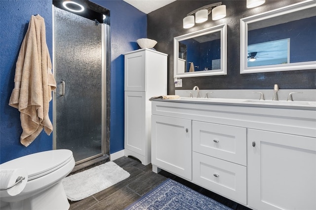 bathroom featuring an enclosed shower, hardwood / wood-style floors, ceiling fan, vanity, and toilet