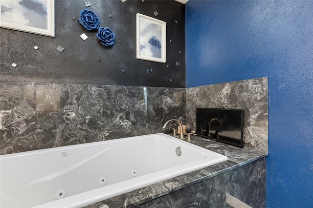 bathroom with tiled bath and a high end fireplace