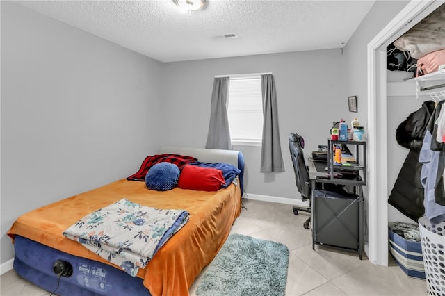 tiled bedroom with a textured ceiling