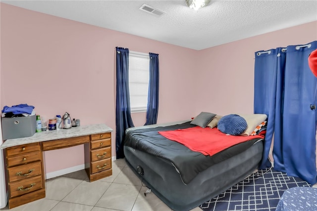 bedroom featuring a textured ceiling and light tile patterned floors