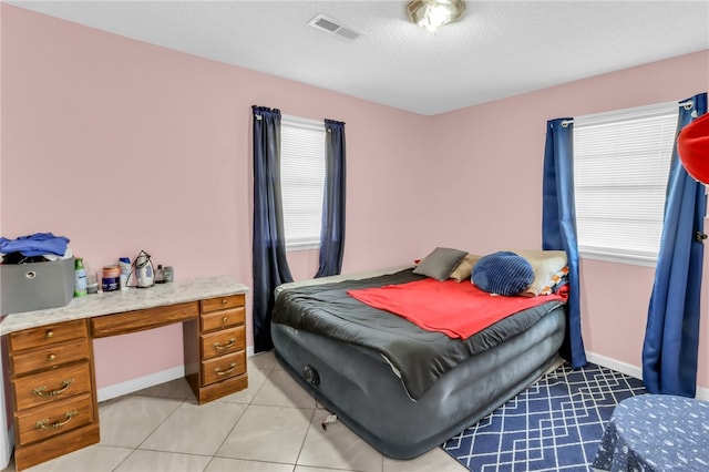 bedroom featuring a textured ceiling and light tile patterned floors