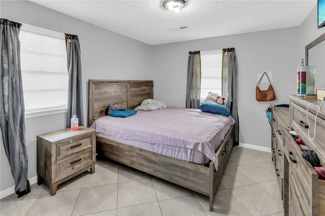 tiled bedroom featuring a textured ceiling