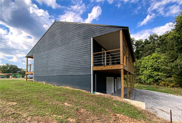 view of side of property featuring a deck and a lawn