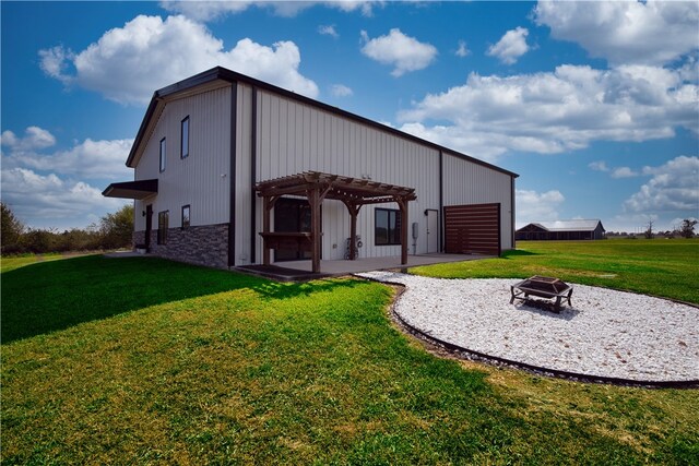 view of outdoor structure featuring a pergola, an outdoor fire pit, and a yard