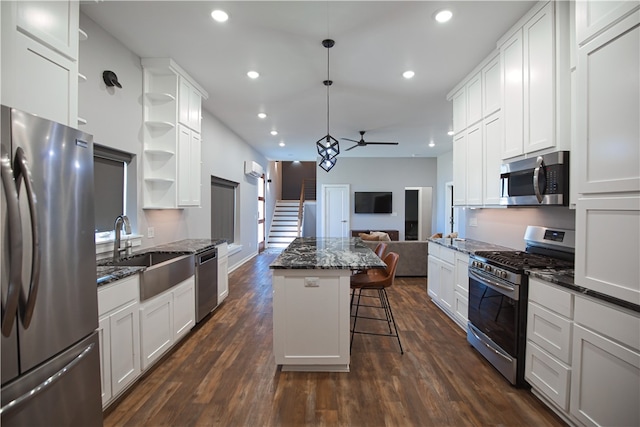 kitchen with stainless steel appliances, dark wood-type flooring, a kitchen bar, and a center island