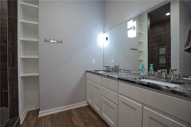 bathroom featuring vanity, a shower, built in features, and hardwood / wood-style flooring