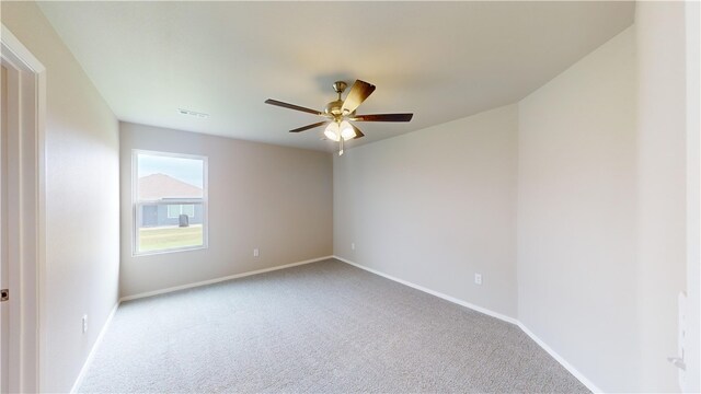 carpeted spare room with ceiling fan