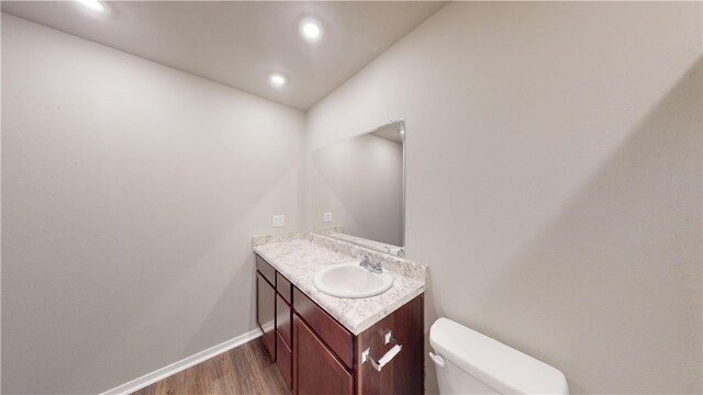 bathroom featuring hardwood / wood-style flooring, vanity, and toilet