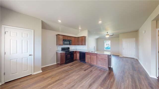 kitchen featuring dark wood-type flooring, kitchen peninsula, black appliances, ceiling fan, and sink