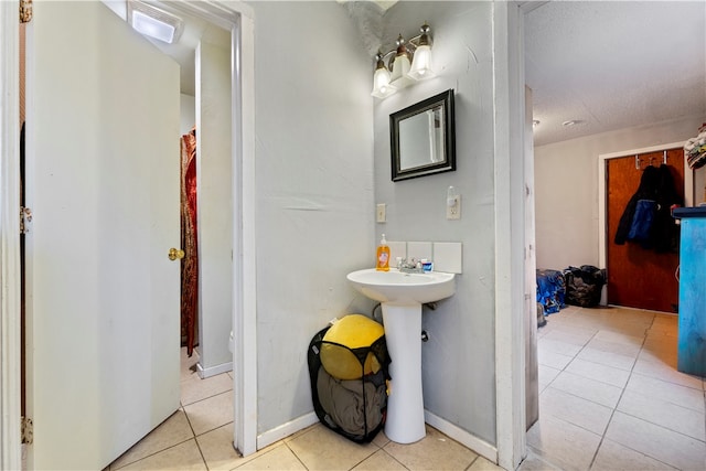 bathroom with tile patterned flooring, sink, and a textured ceiling