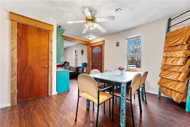 dining room with a textured ceiling, dark hardwood / wood-style floors, and ceiling fan