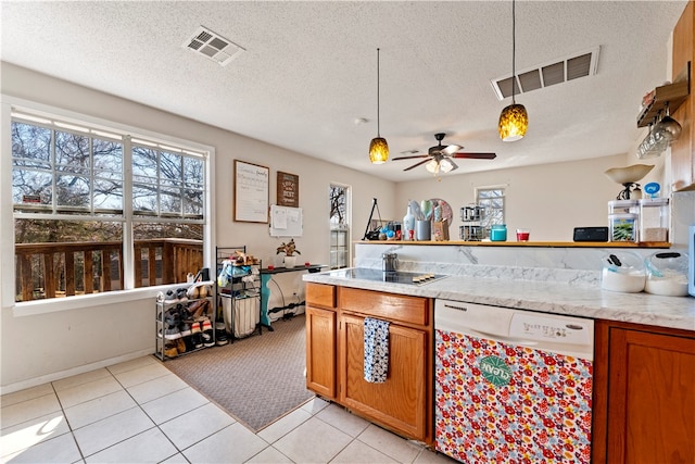 kitchen featuring dishwasher, pendant lighting, a textured ceiling, and a healthy amount of sunlight