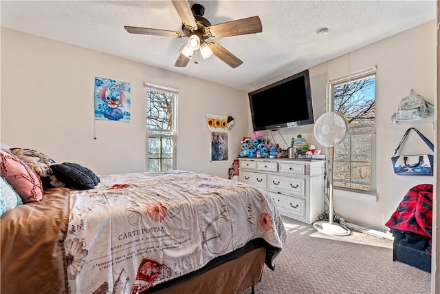 carpeted bedroom featuring a textured ceiling, multiple windows, and ceiling fan