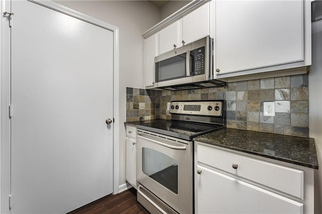 kitchen featuring dark wood-type flooring, stainless steel appliances, tasteful backsplash, white cabinets, and dark stone countertops