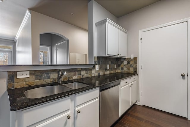 kitchen featuring sink, white cabinets, tasteful backsplash, stainless steel dishwasher, and dark stone counters