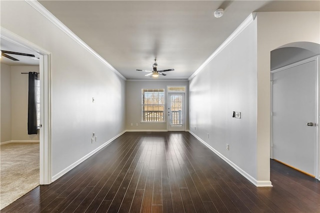 unfurnished living room with ceiling fan, ornamental molding, and dark wood-type flooring