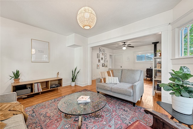 living room with ceiling fan, hardwood / wood-style floors, and a textured ceiling