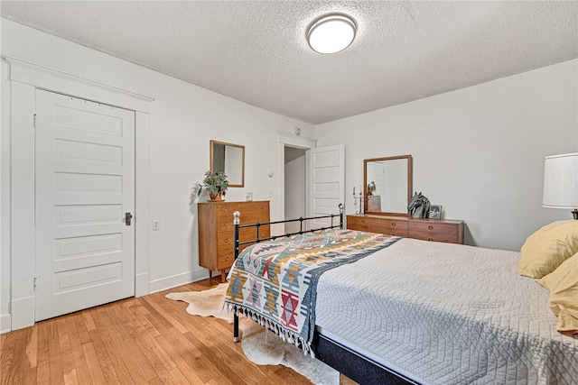 bedroom featuring a textured ceiling and wood-type flooring