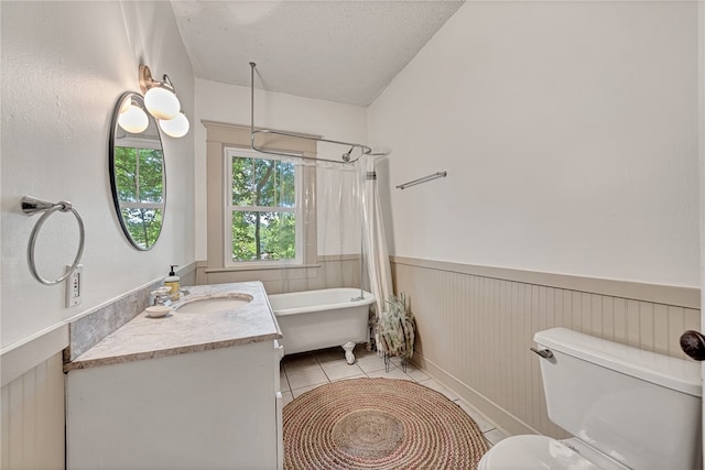 full bathroom featuring shower / bath combination with curtain, a textured ceiling, tile patterned floors, vanity, and toilet