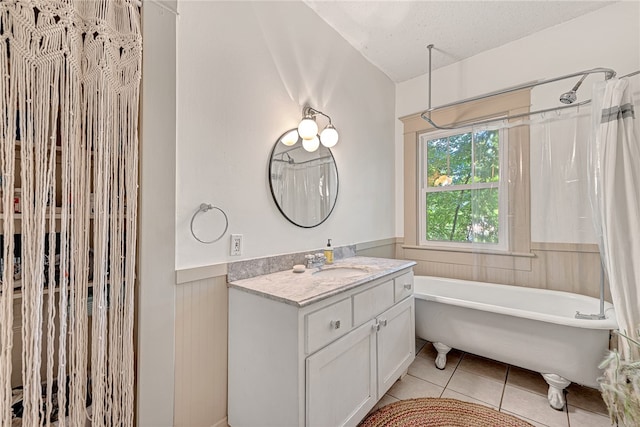 bathroom with a textured ceiling, tile patterned flooring, vanity, and separate shower and tub