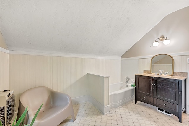 bathroom featuring vaulted ceiling, vanity, and a bathing tub