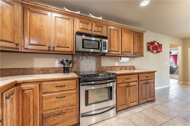 kitchen featuring appliances with stainless steel finishes, tile counters, and light tile patterned floors