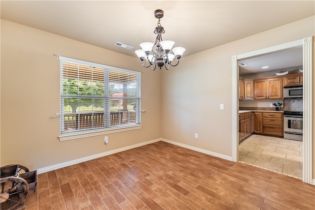 unfurnished dining area featuring a notable chandelier