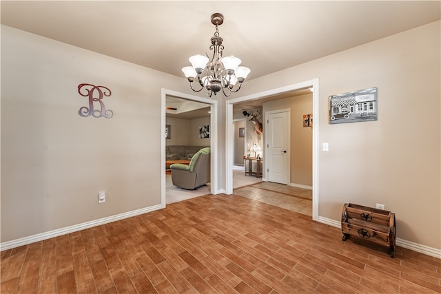 unfurnished dining area with a notable chandelier and hardwood / wood-style flooring