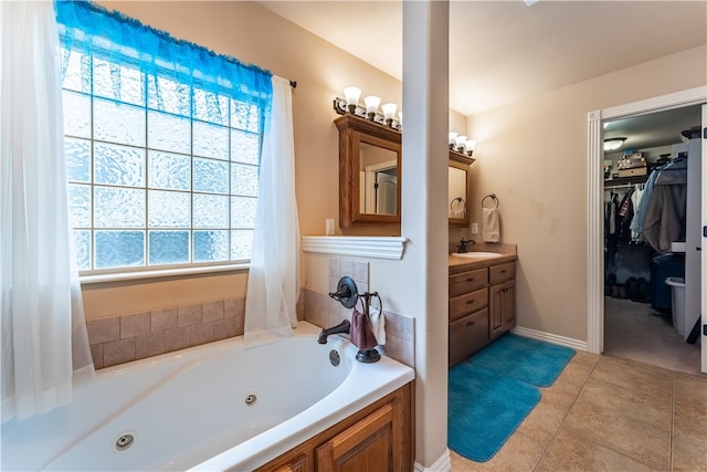 bathroom with a bath, vanity, and tile patterned floors