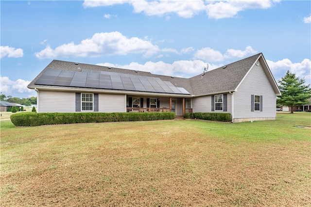 single story home featuring a front lawn, solar panels, and a porch