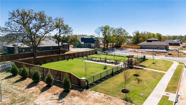 exterior space featuring a residential view, fence, and a lawn