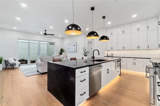 kitchen with recessed lighting, light wood-style floors, stainless steel appliances, and a sink