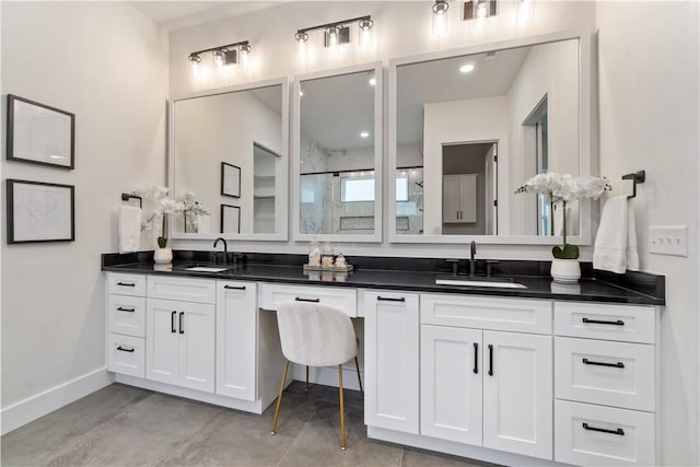 bathroom with baseboards, a sink, and double vanity